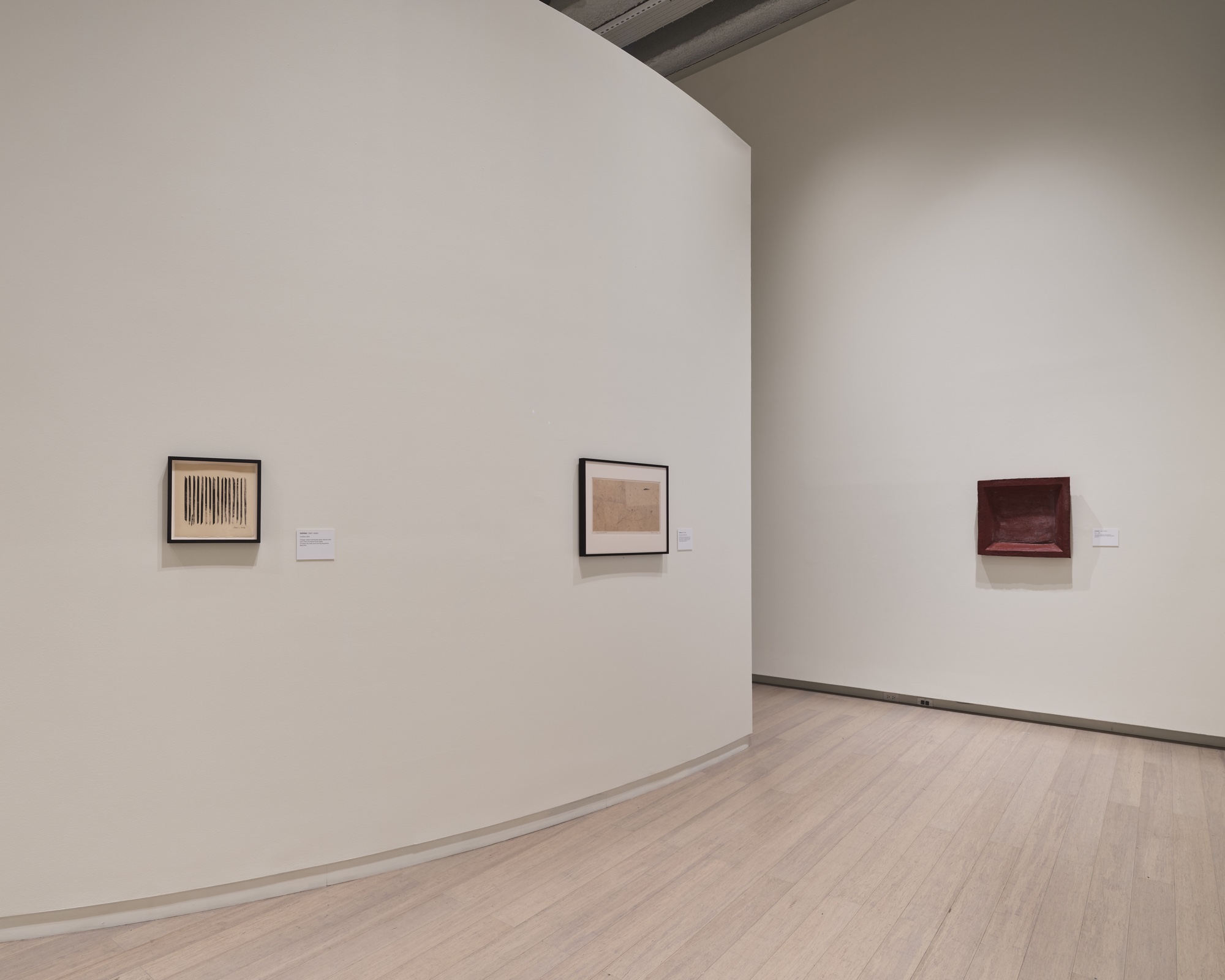 Framed works on the curved gallery wall