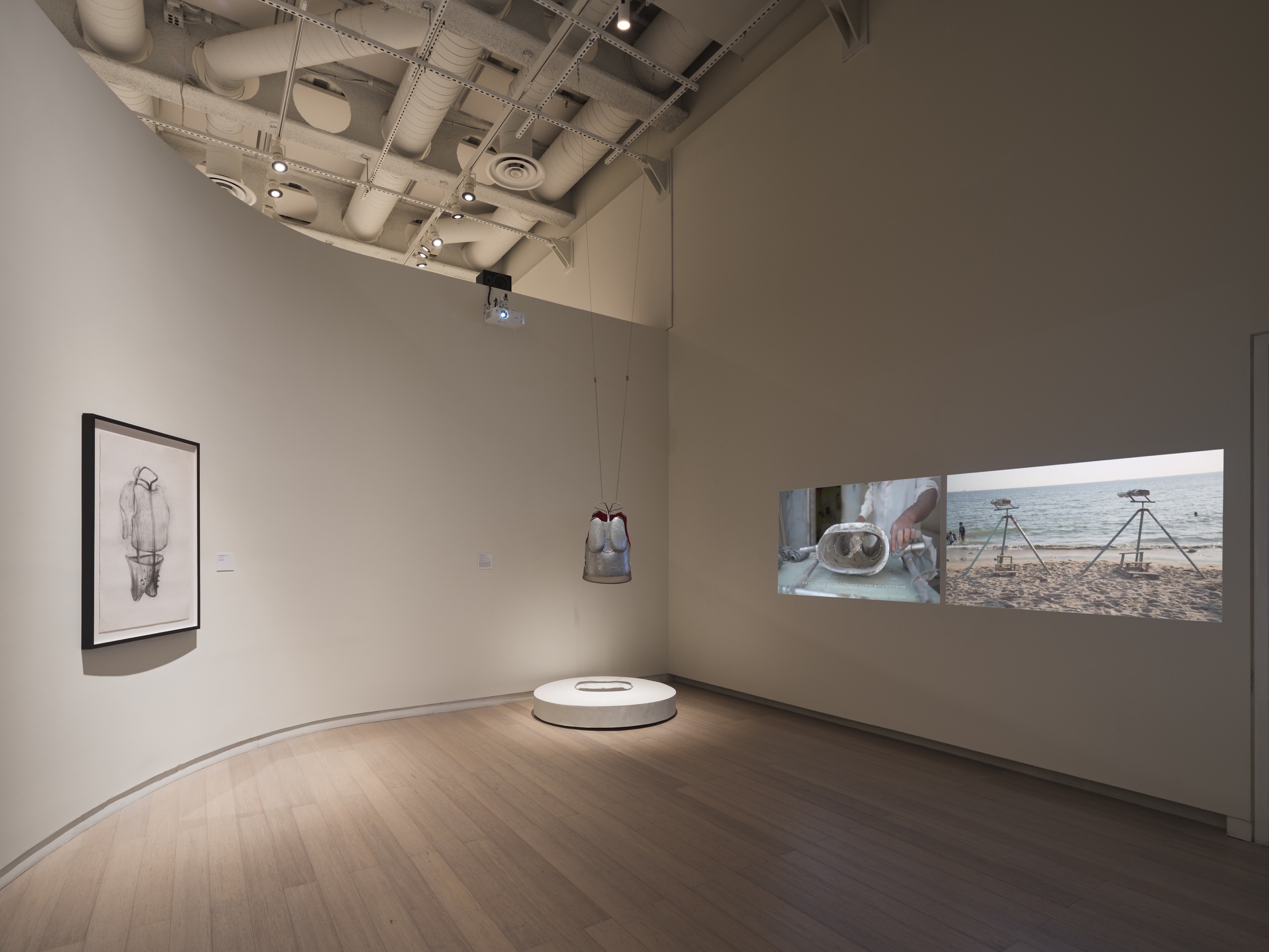 Installation view of Mapping Otherwise at the Wallach Art Gallery, with Naiza Khan’s vest sculpture and video projections